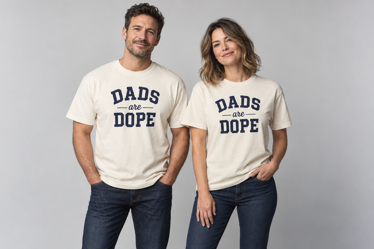 Two adult models wearing cream Dads Are Dope shirts with navy varsity lettering